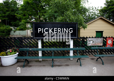 La gare de Pickering, North Yorkshire, Vintage enamel enseignes publicitaire sur station clôture et des bancs sur la plate-forme Banque D'Images