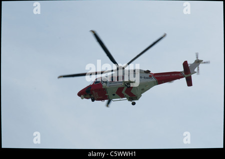 Un hélicoptère Agusta Westland AW139 exploité par la Garde côtière canadienne H.M vole le long de la côte sud et passe Milford-sur-mer. Banque D'Images