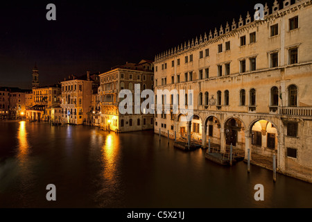 Le magnifique Grand Canal de Venise de nuit avec de l'eau, les taxis, les vaporettos et bateaux amarrés devant les hôtels. Banque D'Images