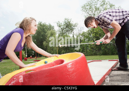 Allemagne, Bavière, Ammersee, Young couple playing mini-golf Banque D'Images