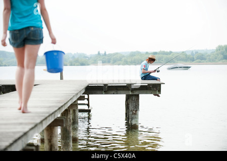 Allemagne, Bavière, Ammersee, Young couple on Jetty, pêche Banque D'Images