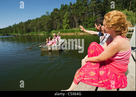 L'Italie, le Tyrol du Sud, grands-parents et petits-enfants en bateau à rames, parents en attente sur jetty Banque D'Images