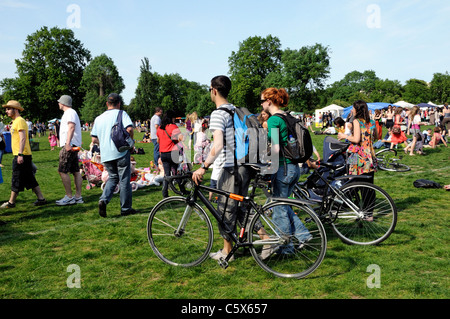 Cycliste poussant leurs vélos dans l'herbe verte de Camden Londres Angleterre Royaume-uni juste Banque D'Images