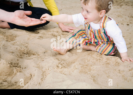 Allemagne, Berlin, de la famille et son (2-3) dans la sandbox, side view, portrait Banque D'Images