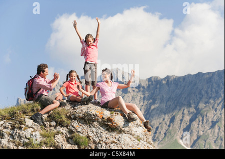 L'Italie, le Tyrol du Sud, Family sitting on rock, man taking photo Banque D'Images