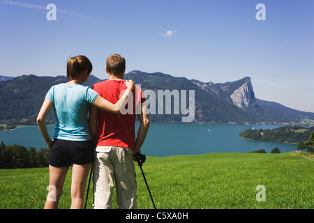 L'Autriche, le lac de Mondsee, Young couple looking at lake, vue arrière Banque D'Images