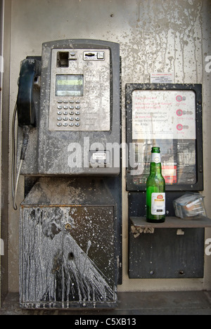 Cabine téléphonique publique britannique barbouillés avec peinture blanche et avec les ordures, à Kingston upon Thames, Surrey, Angleterre Banque D'Images