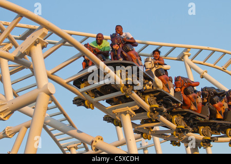 Les visiteurs de Luna Park le nouveau Stepplechase ride comme le soleil se couche sur Coney Island par une chaude nuit de printemps Banque D'Images
