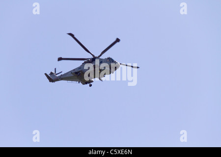 Hélicoptère volant dans le ciel bleu du Royal Naval Air Station à Culdrose, Cornwall, UK Banque D'Images