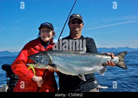 Guide de la pêche sportive féminine holding big quinnat dans'Océan Pacifique Île de Vancouver ouest Banque D'Images