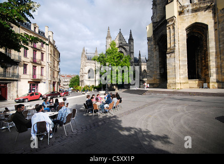 Les gens se détendre dans les restaurants sur place Meynard par la majestueuse église médiévale basilique Saint-Michel à Bordeaux, France. Banque D'Images