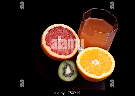 Verre de jus de pamplemousse et d'orange sur le fond noir Banque D'Images