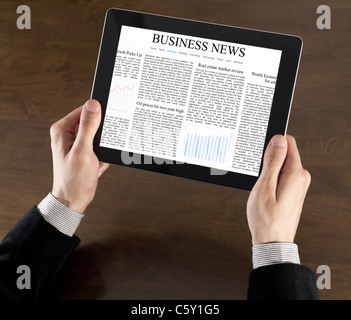 Businessman mains sont maintenant l'appareil à écran tactile avec business news sur écran Banque D'Images