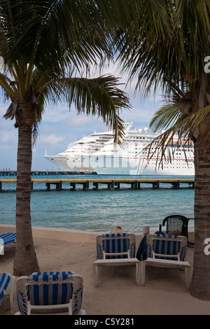 Les navires de croisière Carnival Triumph et de l'Ecstasy au quai sont visibles au travers des palmiers au port de Cozumel au Mexique dans les Caraïbes Banque D'Images