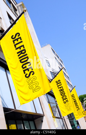 Selfridges & Co Retail Department Retail business shopping store emblématique logo jaune vif bannières bleu ciel soleil jour à West End Londres Angleterre Royaume-Uni Banque D'Images