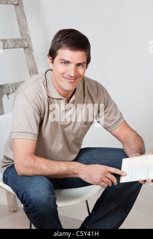 Portrait of senior man holding color swatch dans sa main Banque D'Images