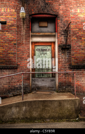 Image hdr d'une porte en verre contre brique rouge dans une ruelle dans la ville minière de Wallace, New York Banque D'Images