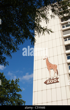 Une girafe affiche à l'extérieur de la station Zoo pointe vers le zoo de Berlin, Allemagne. Banque D'Images