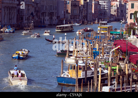 Le magnifique Grand Canal occupé de Venise avec de l'eau, les taxis, les vaporettos, gondoles et bateaux amarrés devant les hôtels. Banque D'Images