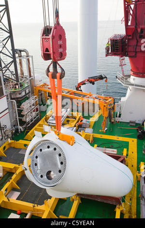 Un cône d'être soulevés en place sur une éolienne au large de la barge à l'aide d'un cric, Kraken, sur l'éolien offshore Walney. Banque D'Images