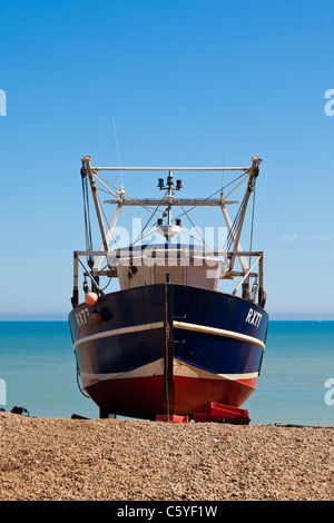 Un bateau de pêche tiré au sec sur la plage à Hastings, Sussex. Banque D'Images