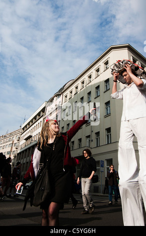 Bouteille de bière fille donnant à l'homme sur pilotis à une parade anarchiste à Prague Banque D'Images