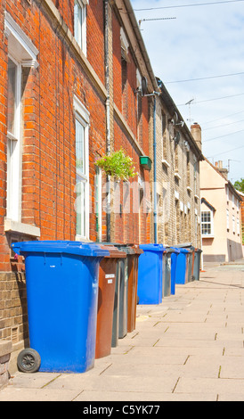 Rangée de bacs plastique wheely en dehors des maisons mitoyennes en Angleterre Banque D'Images