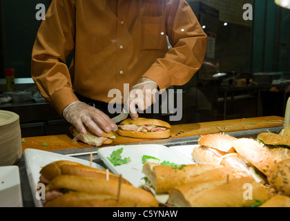 Faire cuire la préparation des sandwichs derrière comptoir cafétéria Banque D'Images