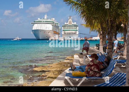 Les touristes sur la plage regarder l'activité des paquebots au port de Cozumel au Mexique dans la mer des Caraïbes Banque D'Images