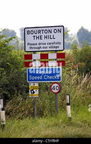 Bourton sur la colline, veuillez traverser avec précaution notre village et les panneaux de contrôle de vitesse réguliers dans les Cotswolds, Gloucestershire, Royaume-Uni en juillet Banque D'Images