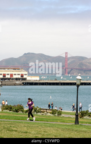 Les piétons profiter de San Francisco Maritime National Historical Park avec le Golden Gate Bridge et la baie à l'arrière-plan Banque D'Images