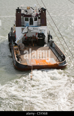 Un remorqueur remorque une barge à l'aide d'un cric à l'éolien offshore Walney. Banque D'Images