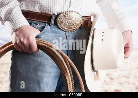 États-unis, Illinois, Metamora, Cowboy holding lasso et hat, mid section Banque D'Images