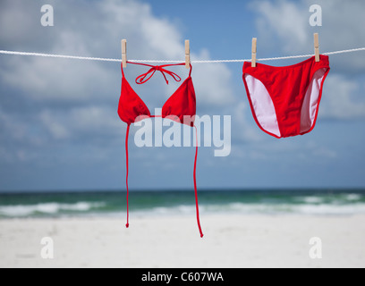 USA, Floride, Saint Pete Beach, Red bikini hanging on clothesline sur beach Banque D'Images