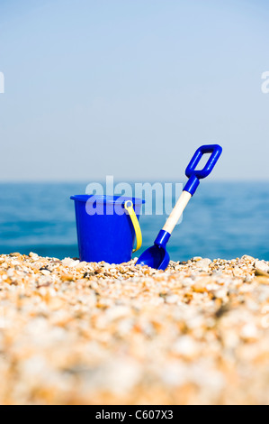 Jouet pour enfants bleu seau et chat sur la plage Banque D'Images