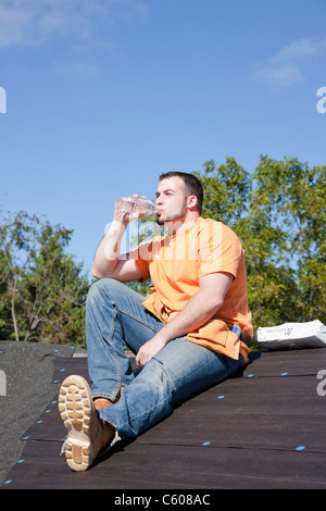 États-unis, Illinois, Metamora, jeune travailleur assis sur le toit et l'eau potable Banque D'Images