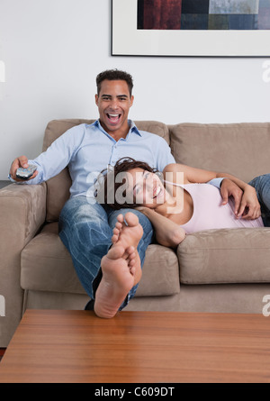 USA, l'État de New York, New York City, jeune couple watching television on sofa Banque D'Images