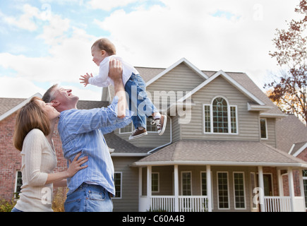 États-unis, Illinois, Metamora, les parents jouant avec baby boy (4-5) in front of house Banque D'Images