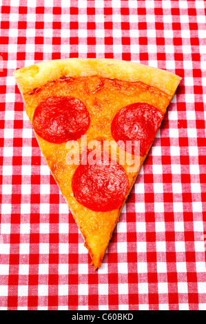 Pepperoni Pizza Slice sur Gros plan vichy rouge Banque D'Images