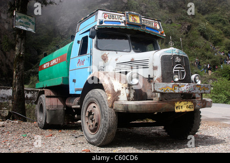 Tata 1210 Vintage se fournissant de l'eau de remplissage d'eau locales bowser jusqu'ses réservoirs sur route de campagne, près de Darjeeling, Inde Banque D'Images