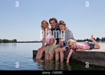 Family relaxing together on dock Banque D'Images