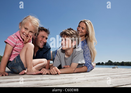 Family relaxing together on dock Banque D'Images