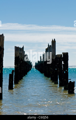 Beau mouillage pourri sur une plage où seuls les piliers sont laissés de côté à une journée ensoleillée, vue sur l'ancien chemin de construction Banque D'Images