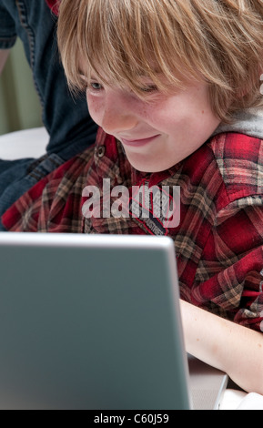 Jeune homme garçon en utilisant son ordinateur portable Banque D'Images