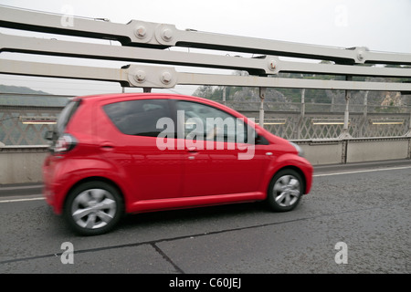 Pour l'échelle, une petite voiture passant devant le fer forgé les chaînes sur le pont suspendu de Clifton, Bristol, Angleterre. Banque D'Images