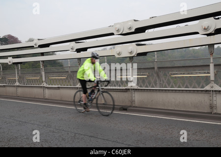 Pour l'échelle, un cycliste en face de passage le fer forgé les chaînes sur le pont suspendu de Clifton, Bristol, Angleterre. Banque D'Images