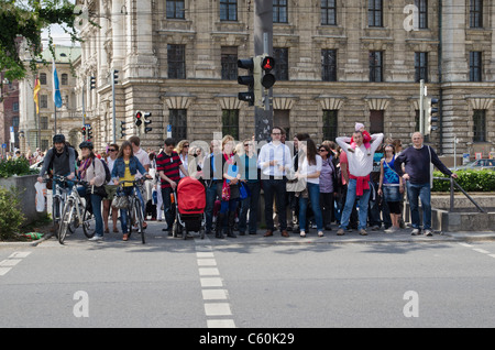 Les piétons attendent pour traverser une route à Munich, Allemagne Banque D'Images