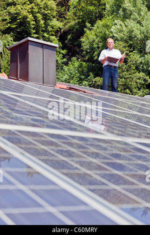 Homme debout sur le toit de panneaux solaires Banque D'Images