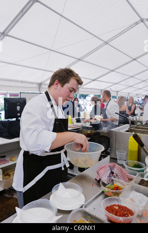 Chef prépare un repas sous chapiteau Banque D'Images