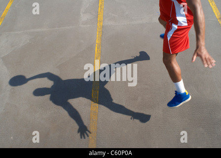 Basket-ball player jumping with ball Banque D'Images